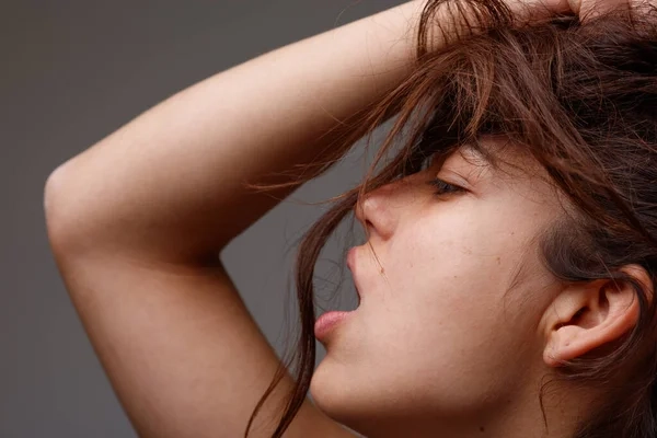 Jovencita gemiendo mientras habla por teléfono